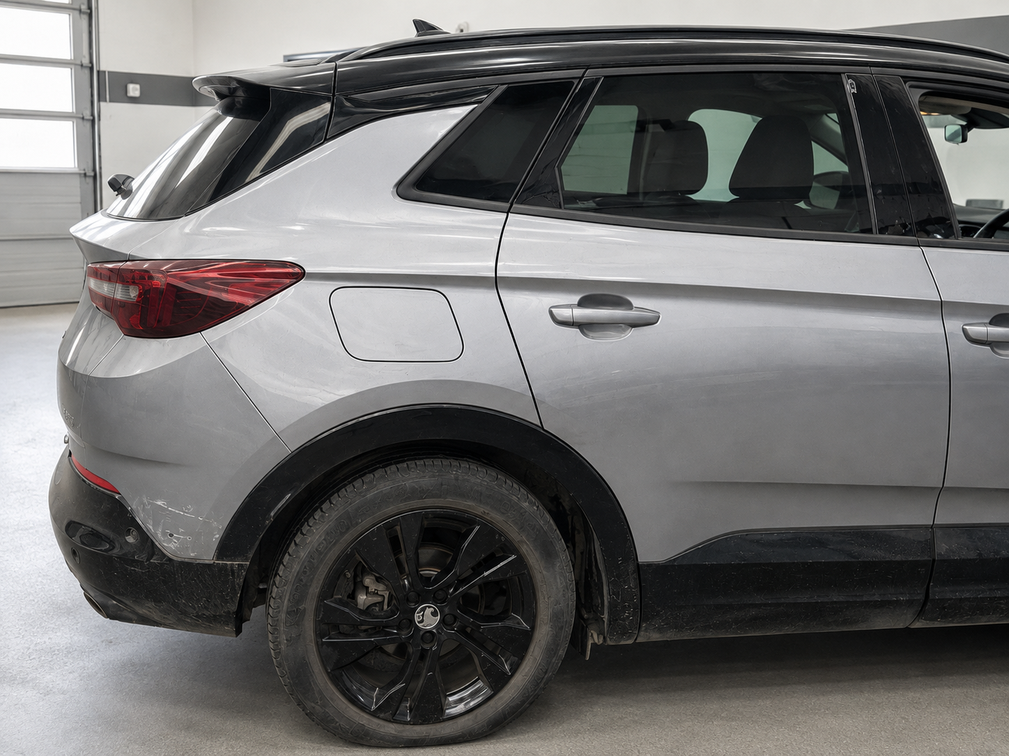 Grey family SUV showing accident damage on arrival at our workshop